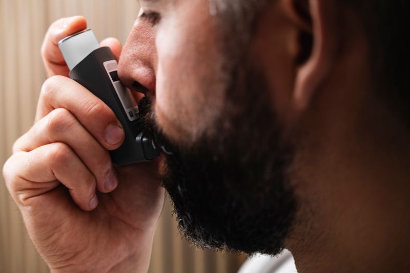 A person using an asthma inhaler